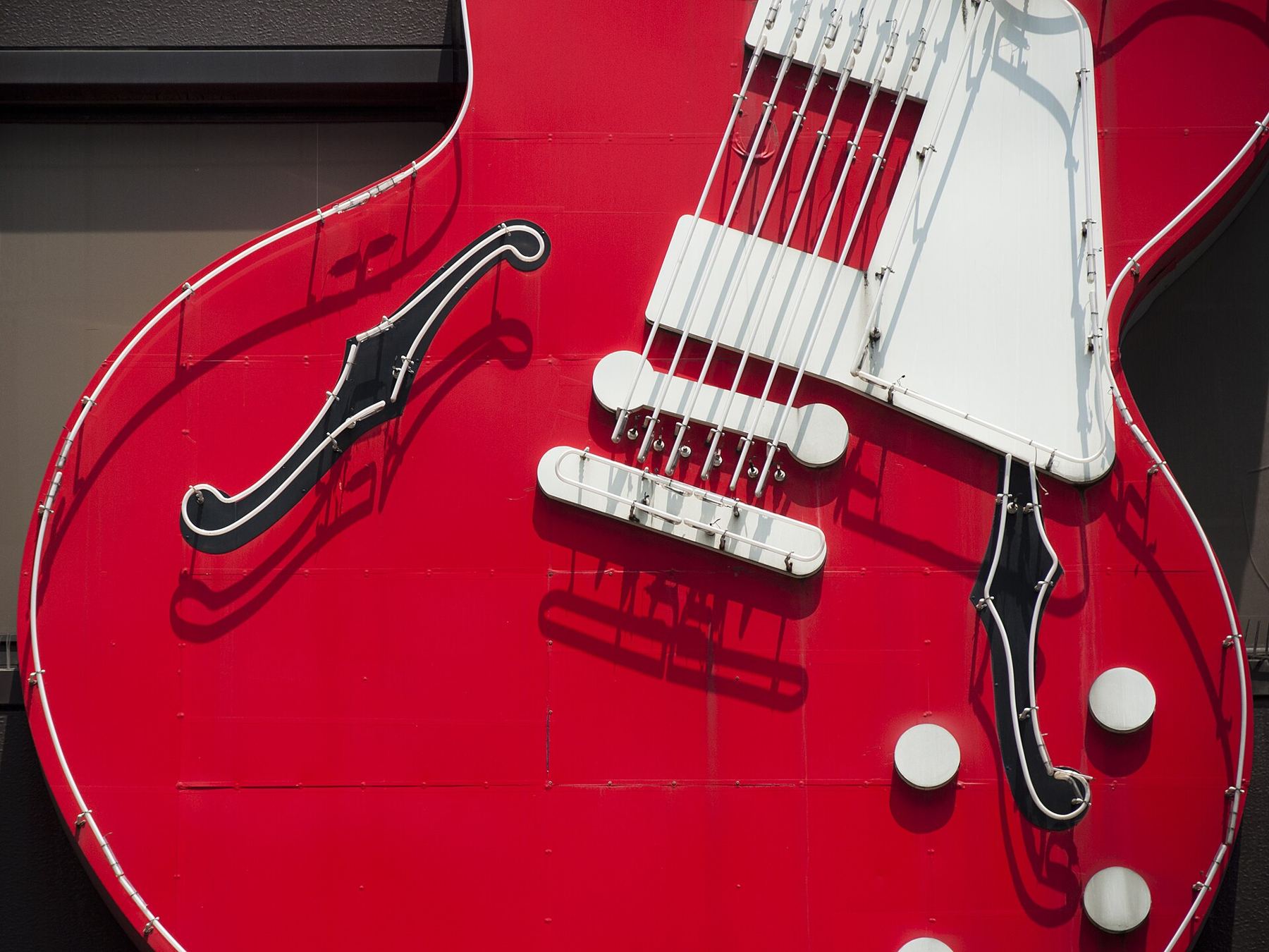 Close-up of a red semi-hollow electric guitar with twin humbucker pickups