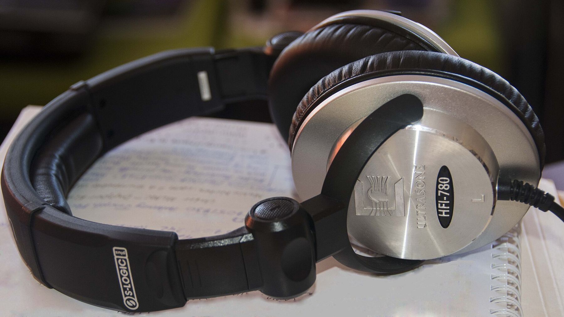 A pair of silver and black studio headphones on a sheet of paper